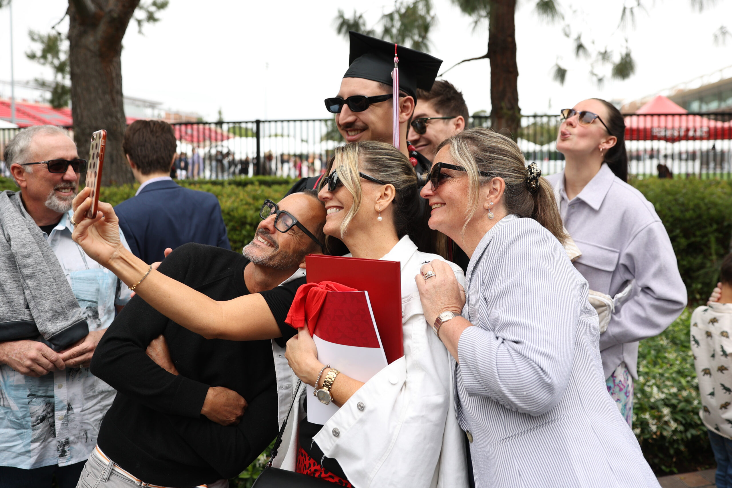 Families taking a selfie with graduate outside of Wilson Field